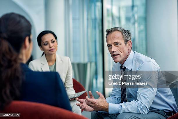 businessman discussing strategy with colleagues - organizzazioni aziendali foto e immagini stock