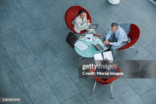 Businesspeople discussing strategy at coffee table Businesspeople discussing strategy at coffee table