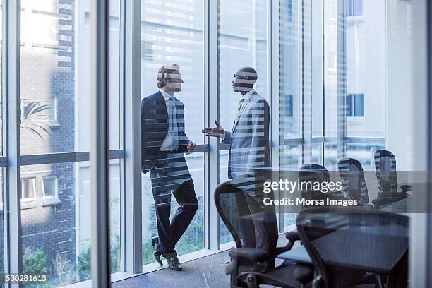 businessmen discussing in board room - meeting candid office suit stock-fotos und bilder