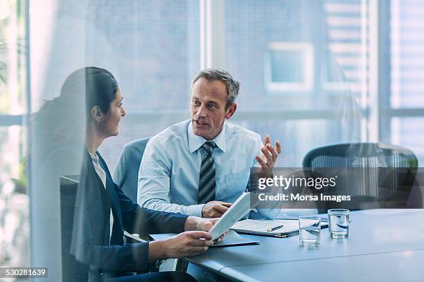 businesspeople discussing strategy in office - mann am tisch mit papier stock-fotos und bilder