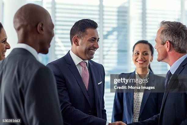 businesspeople shaking hands in office - meeting candid office suit stockfoto's en -beelden