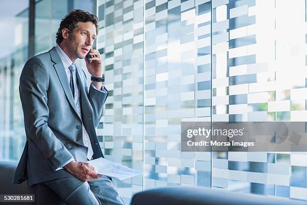 businessman using mobile phone in office - blue suit stock-fotos und bilder