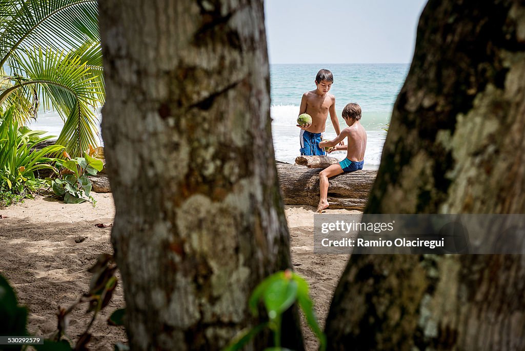 Boys on a beach with a coconut