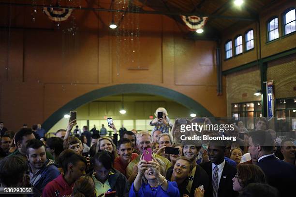 Hillary Clinton, former Secretary of State and 2016 Democratic presidential candidate, center, takes a selfie photograph with attendees after...