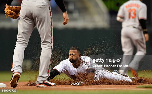 Eduardo Nunez of the Minnesota Twins slides safely into third base against Ryan Flaherty of the Baltimore Orioles during the first inning of the game...