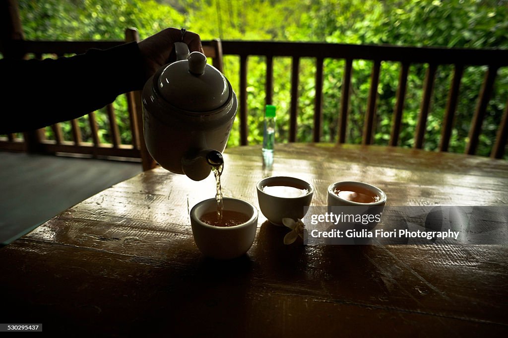 Hand pouring tea from a teapot