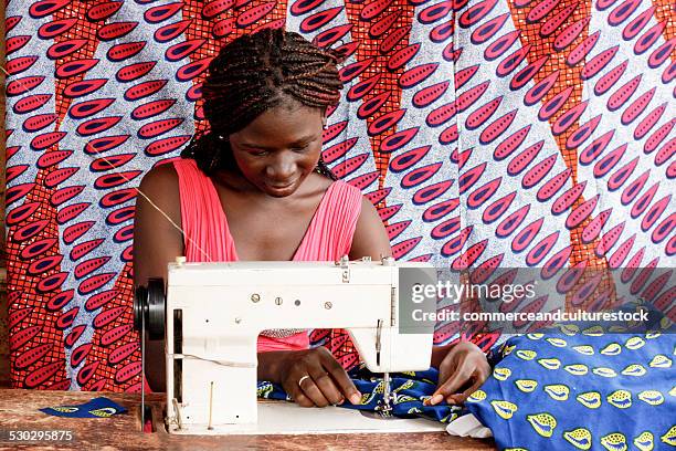 a female tailor with her sewing machine - lendenschurz stock-fotos und bilder
