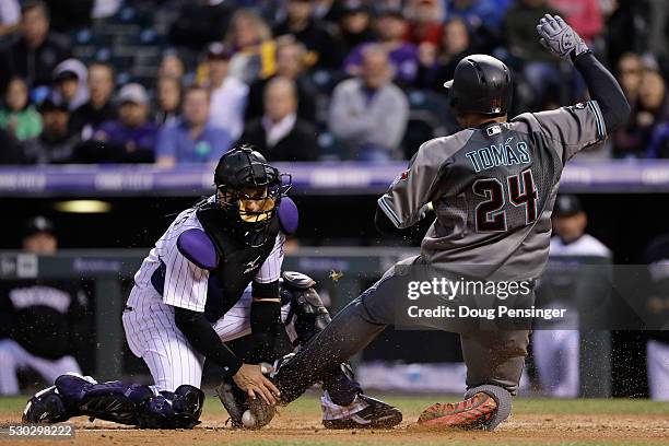 Yasmany Tomas of the Arizona Diamondbacks is tagged out at the plate by catcher Tony Wolters of the Colorado Rockies while trying to score on a...