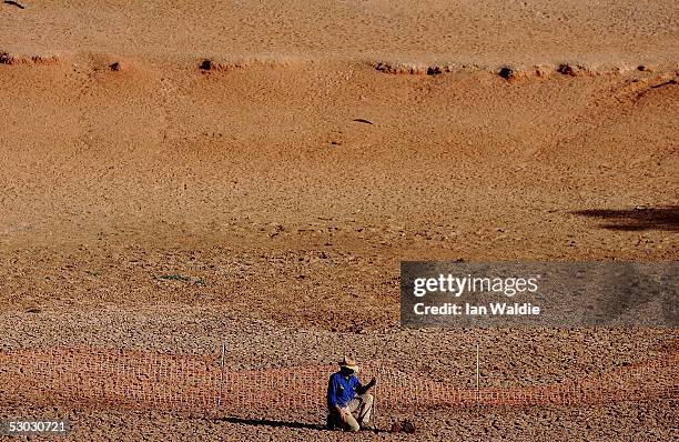 Stockman Gordon Litchfield from Wilpoorinna sheep and cattle station surveys the bottom of a dry dam on his property on June 7, 2005 in Leigh Creek,...