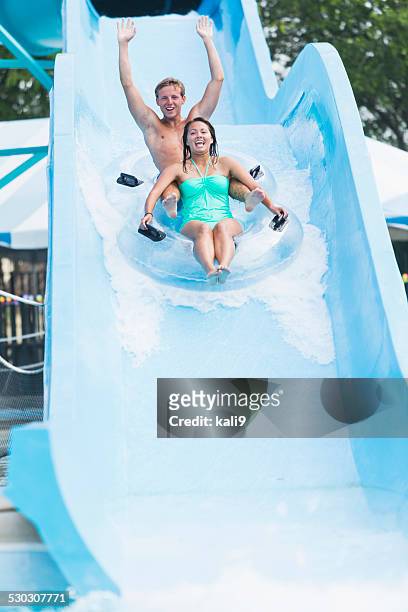 coppia da adolescente su scivolo d'acqua presso il parco divertimenti - acquapark foto e immagini stock
