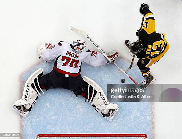 Nick Bonino of the Pittsburgh Penguins scores past Braden Holtby of the Washington Capitals to win 4-3 in overtime in Game Six of the Eastern...