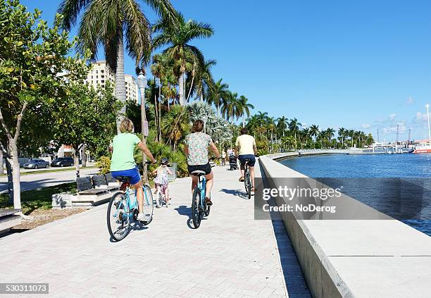 bicycling ao longo do centro da cidade de west palm beach waterfront - west palm beach imagens e fotografias de stock