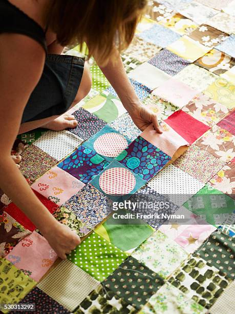 woman working on patches to make quilt - quilt imagens e fotografias de stock