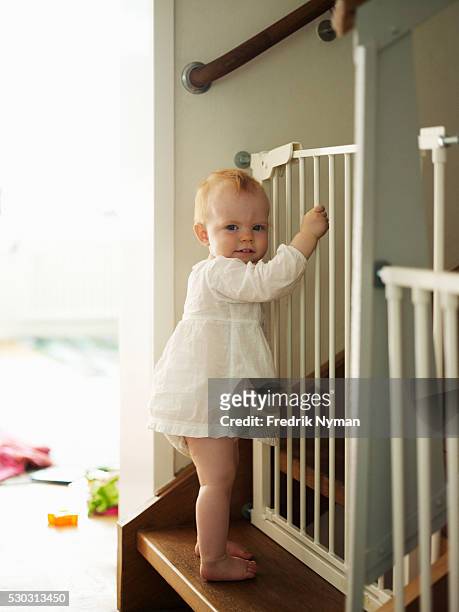 baby girl standing on steps - baby gate imagens e fotografias de stock