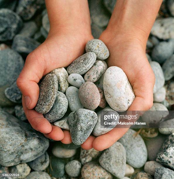 pebbles in human hand - minirock stock pictures, royalty-free photos & images