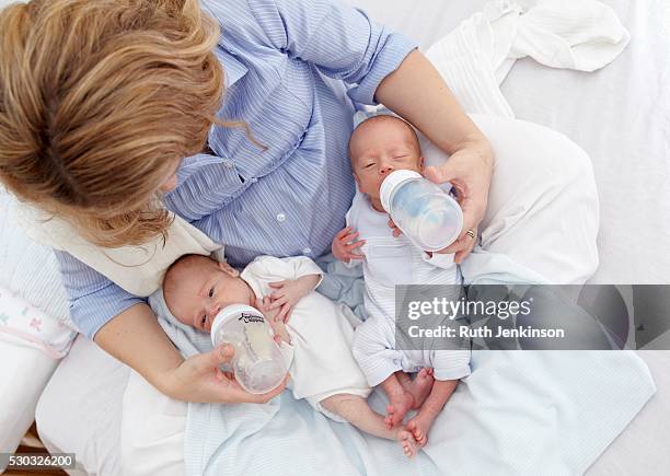 mother feeding two week old fraternal twins. - sisters feeding bildbanksfoton och bilder
