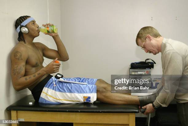 Trainer Jim Gillen tapes up Carmelo Anthony before a Denver Nuggets game against the Orlando Magic on February 20, 2004 at the TD Waterhouse Centre...