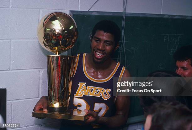 Magic Johnson of the Los Angeles Lakers celebrates with the Walter A. Brown championship trophy after winning Game 6 and the series against the...