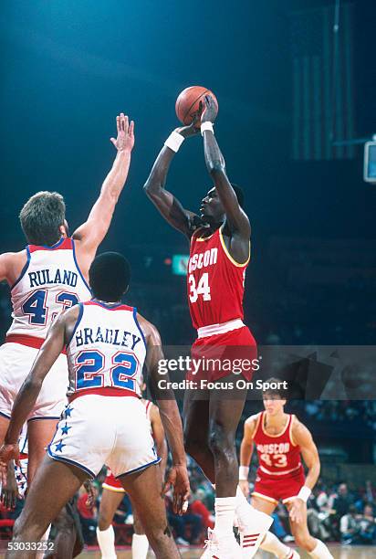 Center Hakeem Olajuwon of the Houston Rockets takes a jumpshot over the Washington Bullets defence during a game at Capital Centre circa 1984 in...