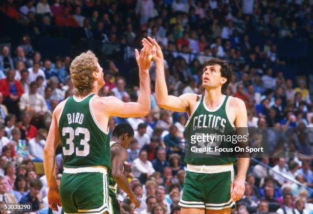 Boston Celtics' Larry Bird and Kevin McHale high-five after a score against the Washington Bullets during a game at Capital Centre circa 1982 in...