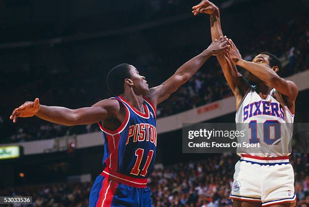 Philadelphia 76ers' Maurice Cheeks shoot over Detroit Pistons' Isiah Thomas during a game at The Spectrum circa the 1980's in Philadelphia,...