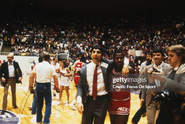 Head coach Jim Valvano of the North Carolina State Wolfpack walks off the court with a player afterwinning a game.