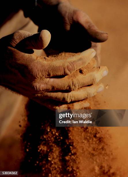 Stockman Gordon Litchfield from Wilpoorinna sheep and cattle station holds a handful of bull dust on his property June 7, 2005 in Leigh Creek,...