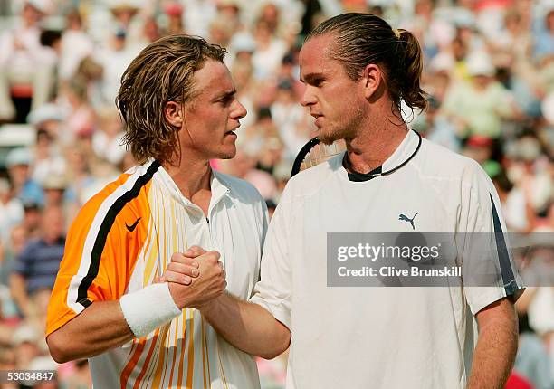 Lleyton Hewitt of Australia shakes hands with Xavier Malisse of Belgium after winning his first round match against at the Stella Artois Tennis...