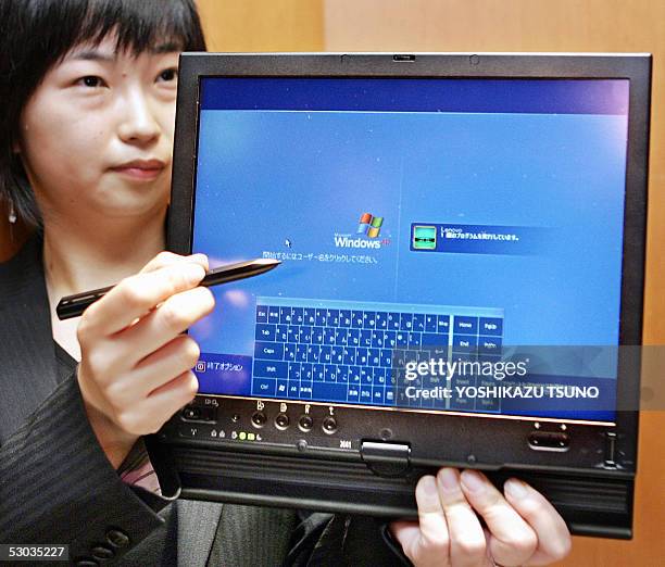 Lenovo Japan employee Kaori Kimura displays the new tablet PC "ThinkPad X41 Tablet", equipped with an Intel's Pentium M 758 procesor on its CPU and...