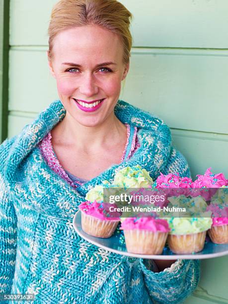 smiling mid adult woman with cupcakes, close-up - muffin stockfoto's en -beelden