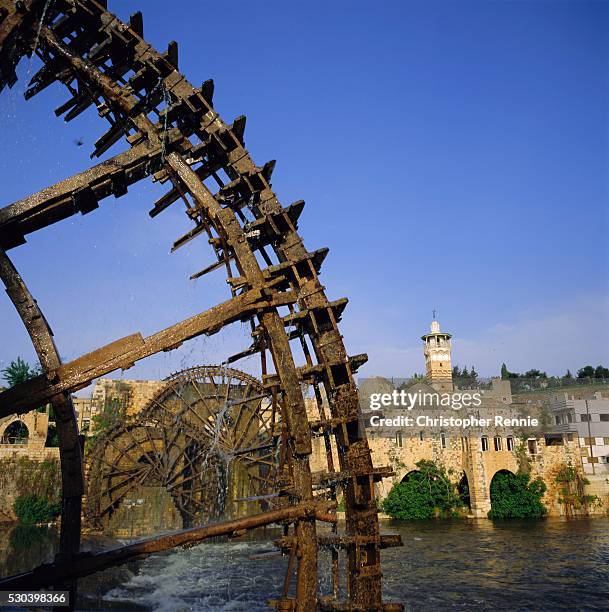 waterwheels (norias) on orontes river, mosque al nuri on far bank, hama, syria, middle east - norias stock pictures, royalty-free photos & images