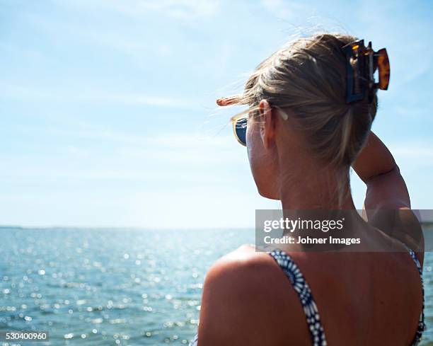 a woman scouting over the ocean - hair clip stock pictures, royalty-free photos & images