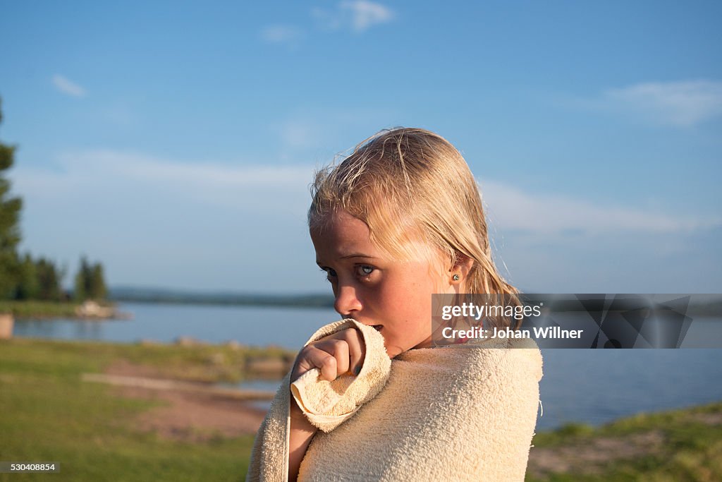 Girl wrapped in towel at lake, Siljan, Dalarna, Sweden