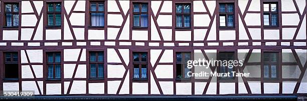 facade of a half timbered house - bavarian man in front of house stock-fotos und bilder