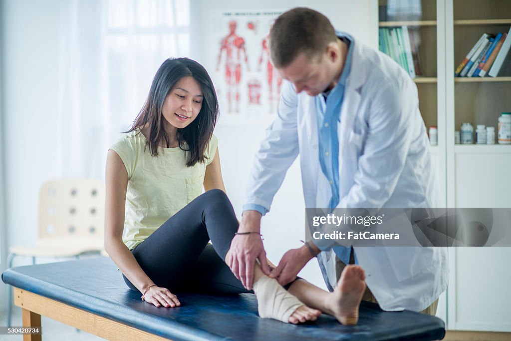 Médecin travaillant sur une femme de la cheville