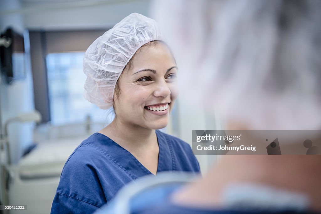 Young female surgeon in hospital smiling, candid portrait