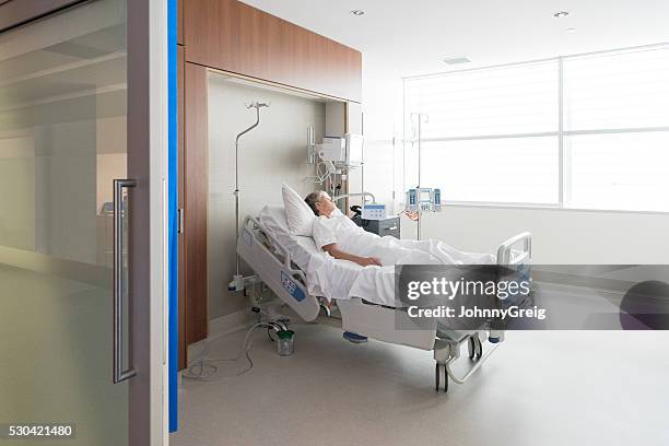 woman lying in bed on hospital ward - hospital bed stockfoto's en -beelden