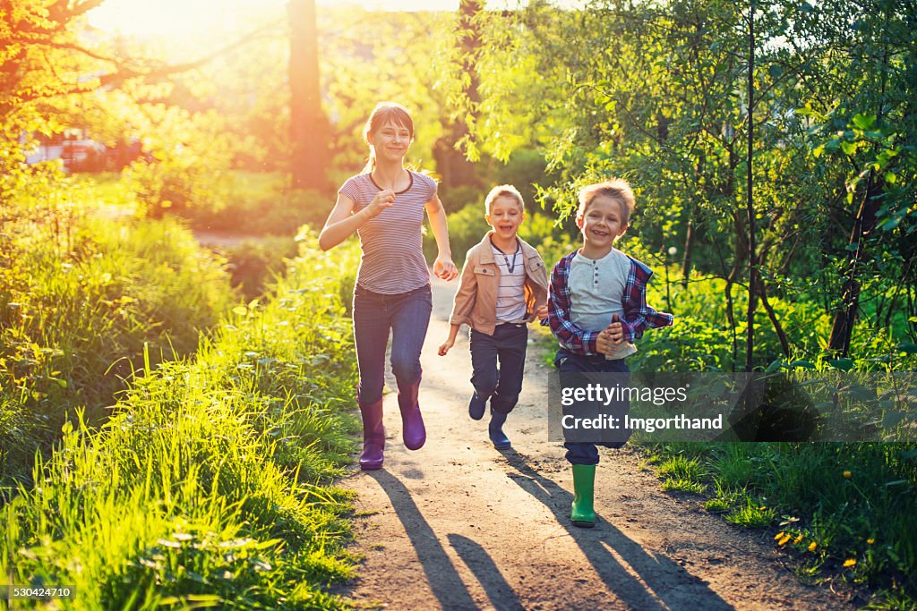 Crianças correndo em um caminho da floresta.