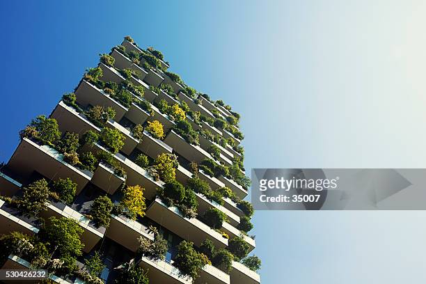 green apartment building - vertical forest stock pictures, royalty-free photos & images