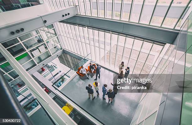 groupe de gens d'affaires dans l'immeuble de bureaux - vue en plongée photos et images de collection