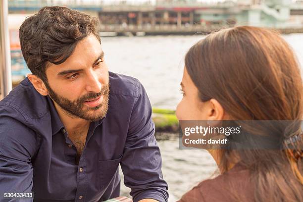 young couple talking in a riverside restaurant - meaningful stock pictures, royalty-free photos & images