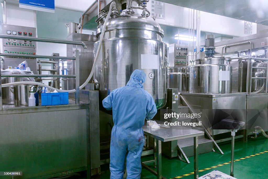 Technician check manufacture equipment and reactors in pharmacy factory