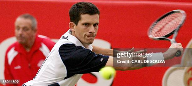 London, UNITED KINGDOM: British player Tim Henman returns a shot during his match against Australian Chris Guccione at Queens Tennis club on the...