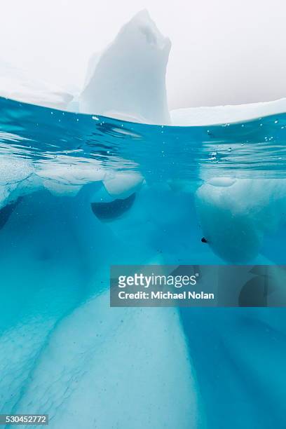above and below view of glacial ice in orne harbor, antarctica, polar regions - iceberg above and below water stock pictures, royalty-free photos & images