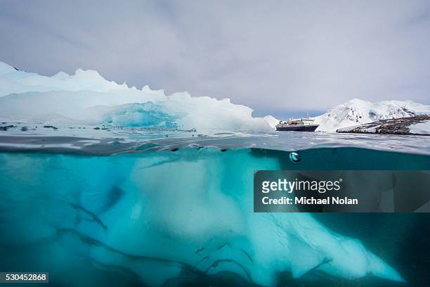 above and below view of glacial ice near wiencke island, neumayer channel, antarctica, polar regions - iceberg above and below water stock pictures, royalty-free photos & images