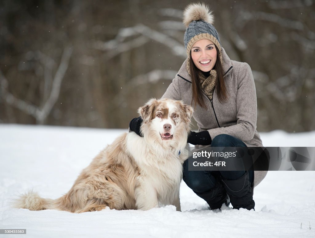 Woman with her Australian Shepherd Dog in the Snow