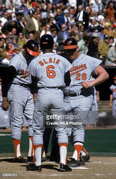 Frank Robinson and Paul Blair of the Baltimore Orioles greet teammate Boog Powell as he touches home plate during a game of the 1970 World Series...