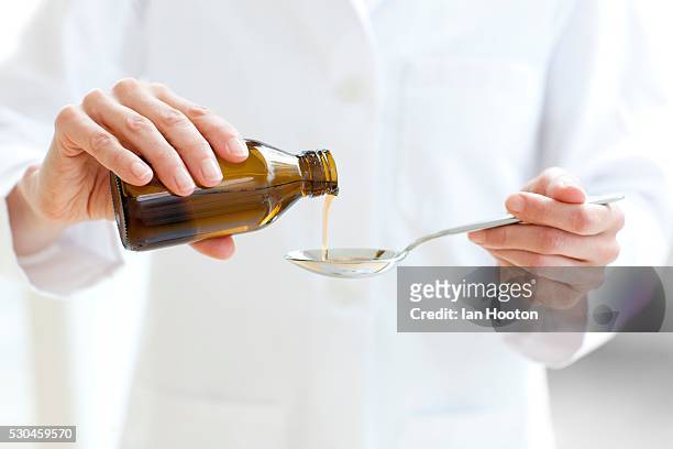 pouring medicine - spoon in hand stock pictures, royalty-free photos & images