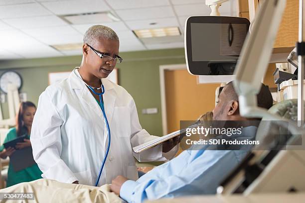 female african american doctor explaining chart to patient in hospital - medical chart stock pictures, royalty-free photos & images