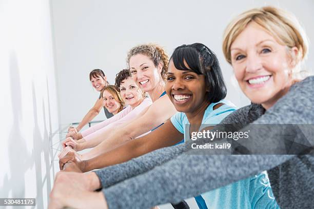 group of women taking an exercise class - mixed age range stock pictures, royalty-free photos & images